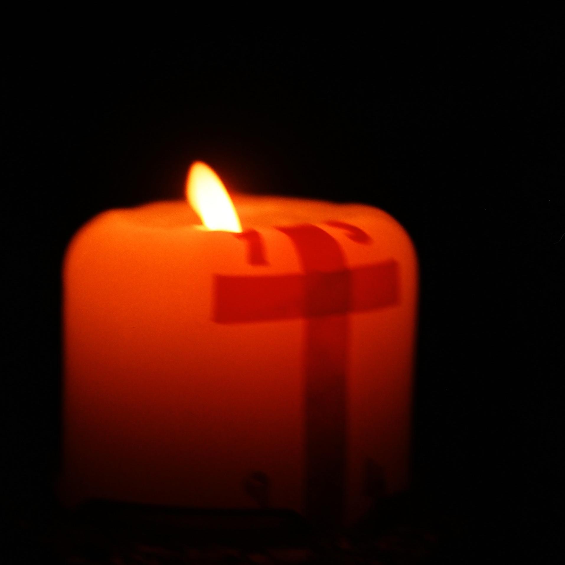 brennende Kerze, Seitenansicht mit angedeutetem Kreuz