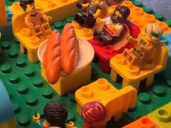 Legomännchen sitzen um einen Tisch mit zwei Broten.