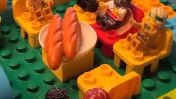 Legomännchen sitzen um einen Tisch mit zwei Broten.